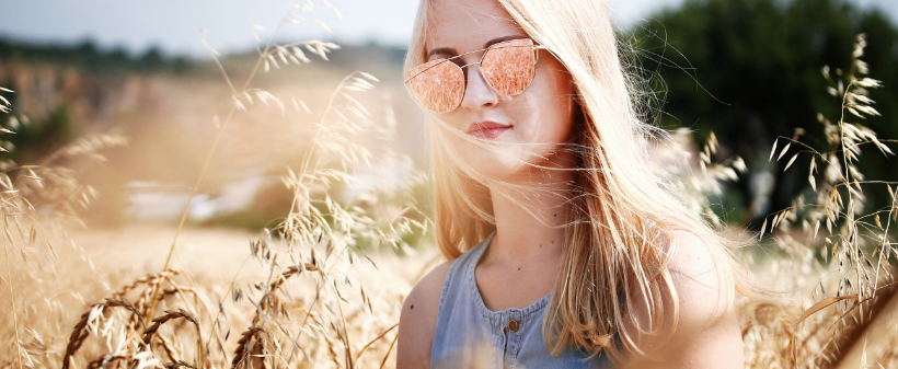 Femme dans les champs avec des lunettes de soleil
